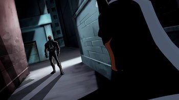 Movie still from “Batman: Death in the Family” (2020), directed by Brandon Vietti – A man standing in front of a door in a room; Wide shot, Low angle