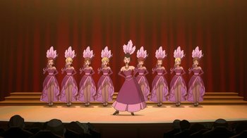 Movie still from “Batman: Gotham by Gaslight” (2018), directed by Sam Liu – A group of women dressed in pink are standing in front of a stage; Wide shot, Low angle
