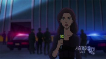 Movie still from “Batman: Hush” (2019), directed by Justin Copeland – A woman is holding a microphone in front of a group of people; Medium shot, Over the shoulder angle