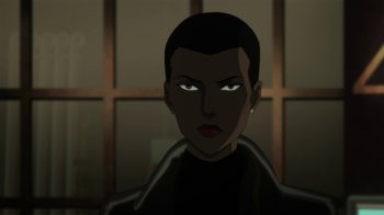 Movie still from “Batman: Hush” (2019), directed by Justin Copeland – A woman with short black hair is looking at the camera; Close Up shot, Over the shoulder angle