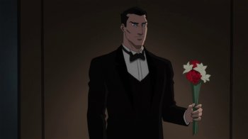 Movie still from “Batman: Hush” (2019), directed by Justin Copeland – A man in a tuxedo holding a flower; Medium shot, Over the shoulder angle