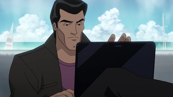 Movie still from “Batman: The Killing Joke” (2016), directed by Sam Liu – A man sitting in front of a laptop computer; Medium shot, High angle