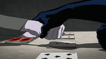 Movie still from “Batman: The Killing Joke” (2016), directed by Sam Liu – A person is playing a card game on a table; Medium shot, High angle