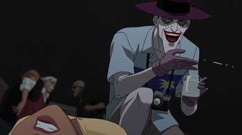 Movie still from “Batman: The Killing Joke” (2016), directed by Sam Liu – A cartoon of the joker holding a camera and smiling; Medium shot, Over the shoulder angle