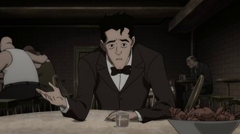 Movie still from “Batman: The Killing Joke” (2016), directed by Sam Liu – A man sitting at a table with a glass of water; Medium shot, Over the shoulder angle