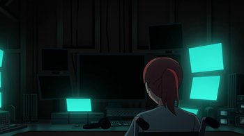 Movie still from “Batman: The Killing Joke” (2016), directed by Sam Liu – A woman sitting in front of computer monitors at a desk; Medium shot, Low angle
