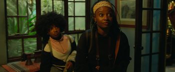 Movie still from “Beast” (2022), directed by Baltasar Kormákur – Two people are sitting in a room looking at the camera; Medium shot, Over the shoulder angle