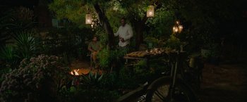 Movie still from “Beast” (2022), directed by Baltasar Kormákur – Two men sitting on a bench in the dark; Wide shot, High angle
