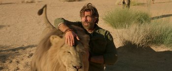Movie still from “Beast” (2022), directed by Baltasar Kormákur – A man petting a lion on his chest; Close Up shot, Low angle