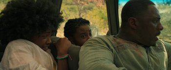 Movie still from “Beast” (2022), directed by Baltasar Kormákur – A woman sitting in the back of a vehicle; Close Up shot, Over the shoulder angle