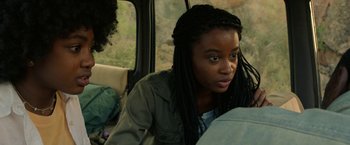 Movie still from “Beast” (2022), directed by Baltasar Kormákur – A young woman sitting in the back seat of a vehicle; Close Up shot, Over the shoulder angle