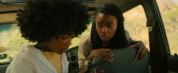 Movie still from “Beast” (2022), directed by Baltasar Kormákur – Two women in a car looking at a cell phone; Close Up shot, Over the shoulder angle
