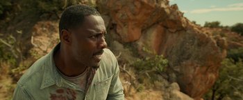 Movie still from “Beast” (2022), directed by Baltasar Kormákur – A person looking away from the camera; Close Up shot, Over the shoulder angle