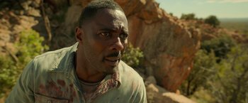 Movie still from “Beast” (2022), directed by Baltasar Kormákur – A person near a rock wall; Close Up shot, Low angle