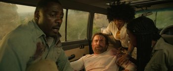 Movie still from “Beast” (2022), directed by Baltasar Kormákur – A man in a car with a bandaged face; Medium shot, Low angle