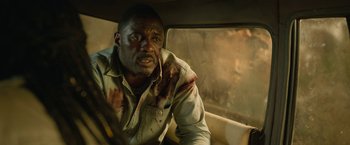 Movie still from “Beast” (2022), directed by Baltasar Kormákur – A man with blood all over his face in a car; Close Up shot, High angle