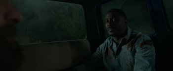 Movie still from “Beast” (2022), directed by Baltasar Kormákur – A man sitting in the back of a car looking out the window; Close Up shot, Over the shoulder angle