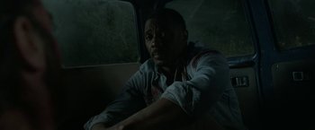 Movie still from “Beast” (2022), directed by Baltasar Kormákur – A man sitting in the back of a vehicle; Close Up shot, High angle