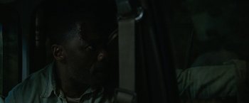 Movie still from “Beast” (2022), directed by Baltasar Kormákur – A man's face in the dark; Close Up shot, High angle