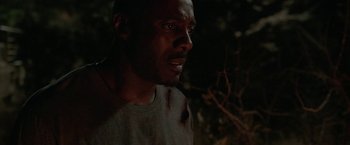 Movie still from “Beast” (2022), directed by Baltasar Kormákur – A person looking at the camera; Close Up shot, Over the shoulder angle