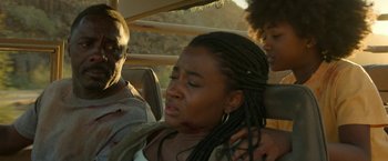Movie still from “Beast” (2022), directed by Baltasar Kormákur – A woman sitting in a car with two other people; Close Up shot, Low angle