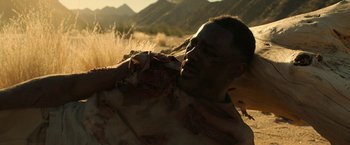 Movie still from “Beast” (2022), directed by Baltasar Kormákur – A man in a field with mountains in the background; Close Up shot, Low angle