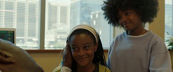 Movie still from “Beast” (2022), directed by Baltasar Kormákur – A young girl is listening to music on her headphones; Close Up shot, Over the shoulder angle