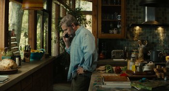 Movie still from “Beautiful Boy” (2018), directed by Felix van Groeningen – A man standing in a kitchen talking on a phone; Medium shot, High angle
