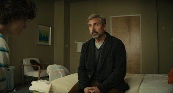 Movie still from “Beautiful Boy” (2018), directed by Felix van Groeningen – A man sitting on top of a bed in a room; Medium shot, Low angle