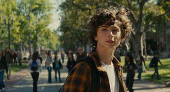 Movie still from “Beautiful Boy” (2018), directed by Felix van Groeningen – A young man is standing on the sidewalk; Medium shot, Over the shoulder angle