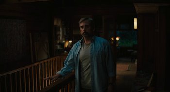 Movie still from “Beautiful Boy” (2018), directed by Felix van Groeningen – A man standing in a dark room next to a railing; Medium shot, Low angle