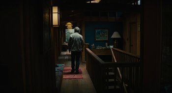 Movie still from “Beautiful Boy” (2018), directed by Felix van Groeningen – A man standing in a room with a lamp on the wall; Wide shot, High angle