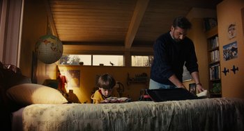 Movie still from “Beautiful Boy” (2018), directed by Felix van Groeningen – A man and a boy are sitting on a bed; Medium shot, Low angle