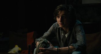 Movie still from “Beautiful Boy” (2018), directed by Felix van Groeningen – A man sitting on a couch in a dark room; Medium shot, Over the shoulder angle