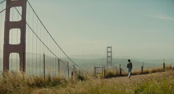 Movie still from “Beautiful Boy” (2018), directed by Felix van Groeningen – A person standing on a dirt road near a bridge; Extreme Wide shot, Low angle