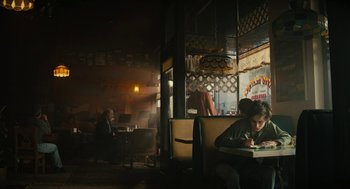 Movie still from “Beautiful Boy” (2018), directed by Felix van Groeningen – A man sitting at a table in front of a window; Wide shot, Low angle