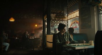 Movie still from “Beautiful Boy” (2018), directed by Felix van Groeningen – A man sitting at a table in front of two women; Wide shot, Low angle