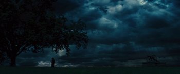 Movie still from “Beautiful Creatures” (2013), directed by Richard LaGravenese – A couple under a tree under a cloudy sky at night; Extreme Wide shot, Low angle