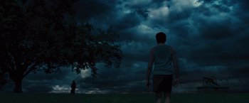 Movie still from “Beautiful Creatures” (2013), directed by Richard LaGravenese – A man standing in a field under a cloudy sky; Extreme Wide shot, Low angle