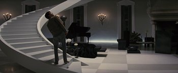 Movie still from “Beautiful Creatures” (2013), directed by Richard LaGravenese – A man standing in front of a grand piano in a living room; Wide shot, High angle