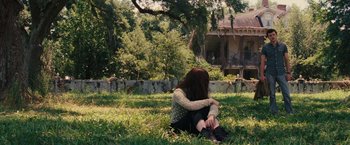 Movie still from “Beautiful Creatures” (2013), directed by Richard LaGravenese – A woman sitting in the grass near a house; Wide shot, High angle