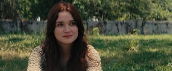 Movie still from “Beautiful Creatures” (2013), directed by Richard LaGravenese – A woman sitting in the grass looking at the camera; Close Up shot, Over the shoulder angle