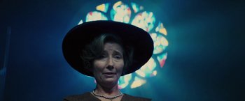 Movie still from “Beautiful Creatures” (2013), directed by Richard LaGravenese – A woman wearing a hat standing in front of a stained glass window; Close Up shot, Low angle