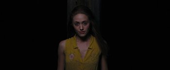 Movie still from “Beautiful Creatures” (2013), directed by Richard LaGravenese – A woman in a yellow shirt standing next to a wooden wall; Medium shot, Low angle