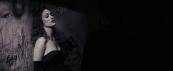 Movie still from “Beautiful Creatures” (2013), directed by Richard LaGravenese – A woman in a black dress standing next to a brick wall; Medium shot, Low angle