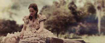 Movie still from “Beautiful Creatures” (2013), directed by Richard LaGravenese – A woman sitting on the ground in a dress; Medium shot, Low angle