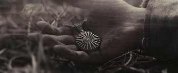 Movie still from “Beautiful Creatures” (2013), directed by Richard LaGravenese – A person holding a silver object in their hand; Extreme Close Up shot, High angle