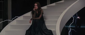 Movie still from “Beautiful Creatures” (2013), directed by Richard LaGravenese – A woman sitting on top of a set of stairs wearing a black dress; Medium shot, High angle