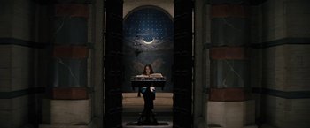 Movie still from “Beautiful Creatures” (2013), directed by Richard LaGravenese – A woman sitting on a chair in front of an open book; Wide shot, Low angle