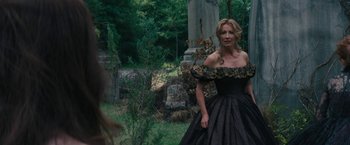 Movie still from “Beautiful Creatures” (2013), directed by Richard LaGravenese – A woman in a black dress standing next to a tree; Medium shot, Over the shoulder angle
